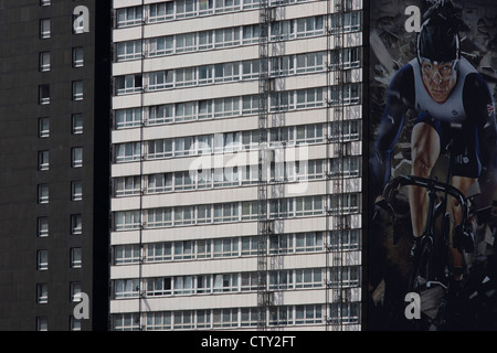 Un'immagine del British sprint ciclismo eroe e 5 volte Gold medallist Sir Chris Hoy compare sul lato di un blocco a torre che si affaccia sul Parco Olimpico, visto durante le Olimpiadi di Londra 2012, la trentesima Olimpiade. Hoy approva il marchio Gillette il cui slogan è "Niente batte un grande inizio' e si vede il suo compagno di squadra GB via bike. Foto Stock