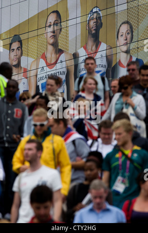 Con il gigante presenza del Team GB ruolo modello di atleta eroi dietro di loro, spettatore folle scendere una scalinata al Westfield Shopping Complex, Stratford che conduce al Parco Olimpico durante le Olimpiadi di Londra 2012, la trentesima Olimpiade. L'annuncio è per calzature sportive marca Adidas e loro "prendere la fase " campagna, compresi subacqueo Tom Daley, ginnasta Louis Smith, triple ponticello Phillips Idowu e il Darling britannica di atletica leggera, heptathlete medaglia d'oro Jessica Ennis. Foto Stock