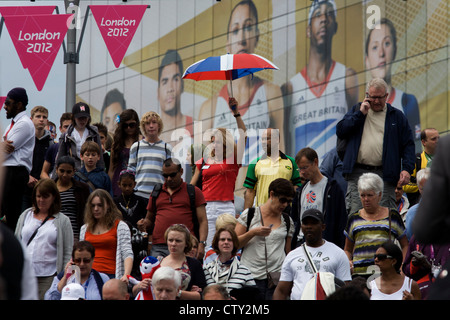 Con il gigante presenza del Team GB ruolo modello di atleta eroi dietro di loro, spettatore folle scendere una scalinata al Westfield Shopping Complex, Stratford che conduce al Parco Olimpico durante le Olimpiadi di Londra 2012, la trentesima Olimpiade. L'annuncio è per calzature sportive marca Adidas e loro "prendere la fase " campagna, compresi subacqueo Tom Daley, ginnasta Louis Smith, triple ponticello Phillips Idowu e il Darling britannica di atletica leggera, heptathlete medaglia d'oro Jessica Ennis. Foto Stock