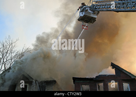 Detroit Fire Department piattaforma aerea estinzione di due appartamento edificio incendi, Detroit Michigan STATI UNITI Foto Stock