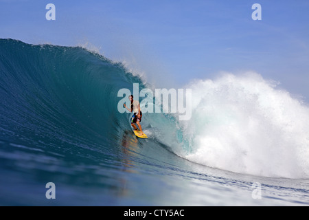 Australian surfer surf di una grande onda verde in una remota isola tropicale a nord di Sumatra, Indonesia. Foto Stock