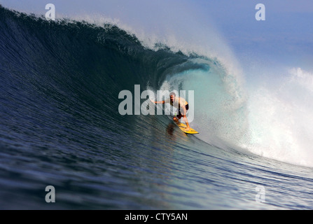 Australian surfer surf di una grande onda verde in una remota isola tropicale a nord di Sumatra, Indonesia. Foto Stock