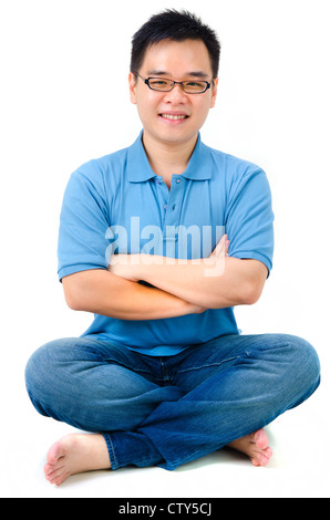 Giovani asiatici Casual Uomo seduto sul pavimento Foto Stock