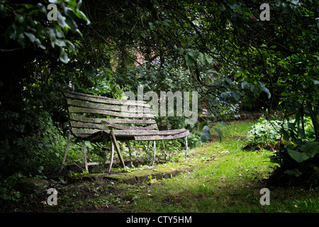 Antica sede del giardino in una selvaggia giardino inglese Foto Stock