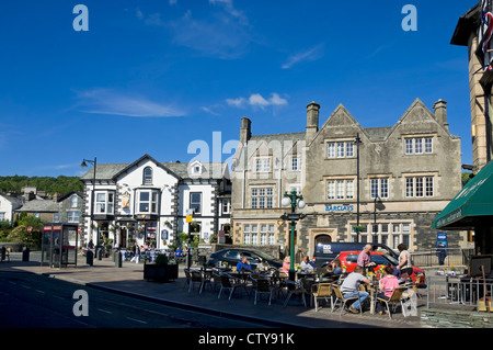 Persone visitatori turisti seduti al di fuori del bar caffetteria nel centro della città in estate Windermere Cumbria Inghilterra Regno Unito GB Gran Bretagna Foto Stock