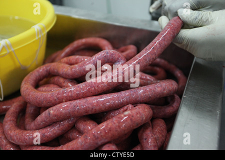 Rendendo la salsiccia Merguez una salsiccia piccante da Algeria e Nord Africa. Foto Stock