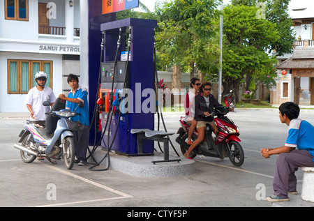 Scooters riempire fino ad una stazione di benzina sulla isola di Ko Samui, Thailandia. Foto Stock