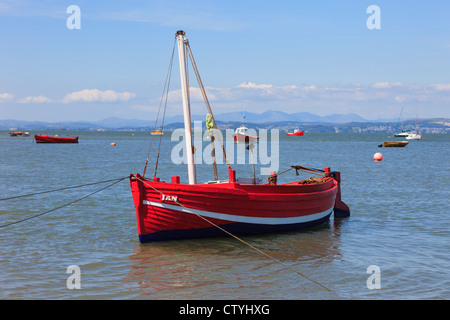 Piccolo rosso barca da pesca ormeggiate nella baia di Morecambe situata ad alta marea su north Lancashire costa, Inghilterra, Regno Unito, Gran Bretagna Foto Stock