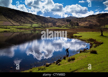 Pescatore a mosca a Watendlath Tarn, Lake District, Inghilterra Foto Stock