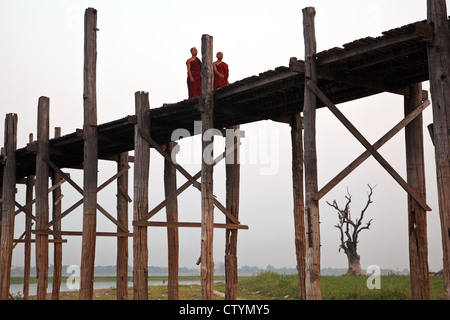 I monaci attraversando U Bein Bridge - il più lungo ponte in teak (footbridge) nel mondo in Amarapura, Mandalay City, Myanmar (Birmania). Foto Stock