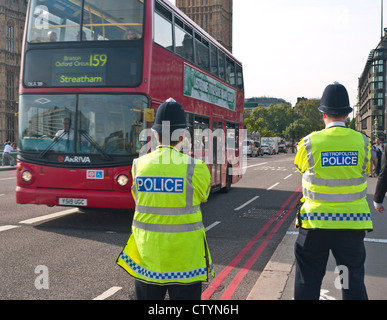 La Metropolitan Police di ufficiali a dovere a Westminster Bridge percorso rosso Case del Parlamento London REGNO UNITO Foto Stock