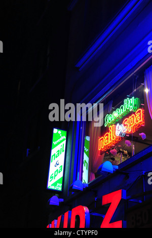 Ritratto notturno rosso verde insegne al neon, edificio blu, 'David Z.' negozio di scarpe, 'Serenity chiodo & Spa " salon, 846 7th Avenue, New York Foto Stock