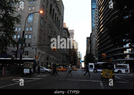 Nel tardo pomeriggio vista persone, pedicabs, automobili, Central Park West Drive a West 59th Street verso la settima avenue urban vicolo, New York Foto Stock