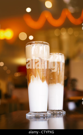 Caffè ghiacciato latte con luci su sfondo in un bicchieri alti, shallow dof Foto Stock