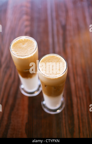 Caffè ghiacciato latte sul tavolo di legno in bicchieri alti e poco profonda dof Foto Stock