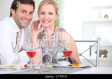 Un elegante giovane avente la cena e sorridente a noi. Foto Stock