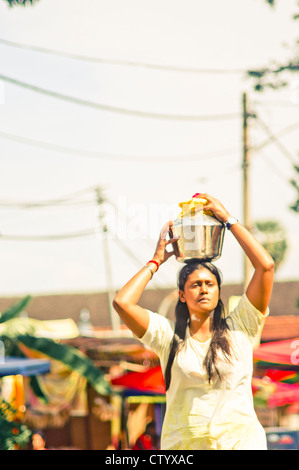 Thaipusam festival, una donna devoto sta portando a una pentola di latte di vacca come l'offerta. Penang, Malesia 2011. Foto Stock