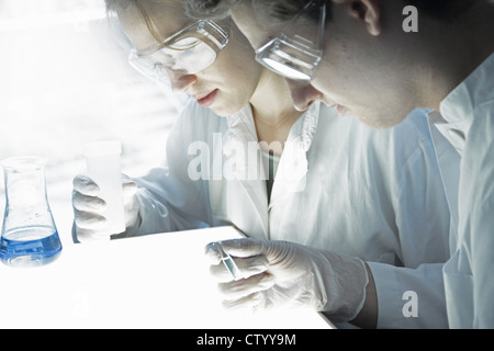 Gli scienziati esaminando le provette per la prova in laboratorio Foto Stock