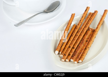 Lunghe e sottili bastoncini di biscotto e una tazza di tè Foto Stock