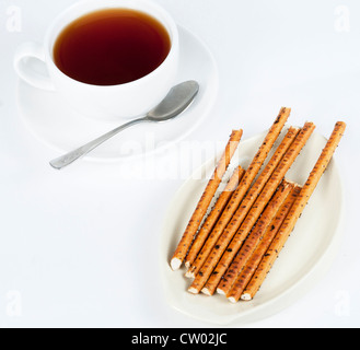 Lunghe e sottili bastoncini di biscotto e una tazza di tè Foto Stock