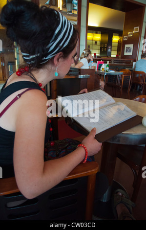 Femmina nel suo fine 20s studiando il menu Café Slavia Praga Repubblica Ceca Europa Foto Stock