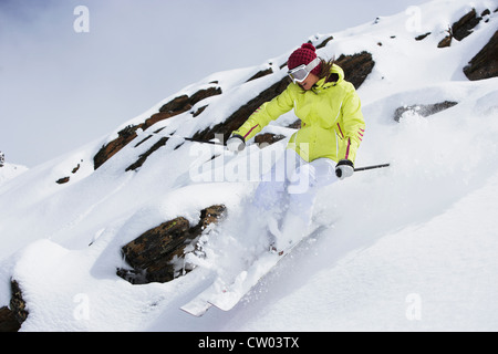 Sciatore rallenta sul pendio nevoso Foto Stock