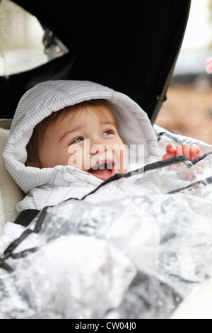 Ragazzo sorridente di equitazione in passeggino all'aperto Foto Stock