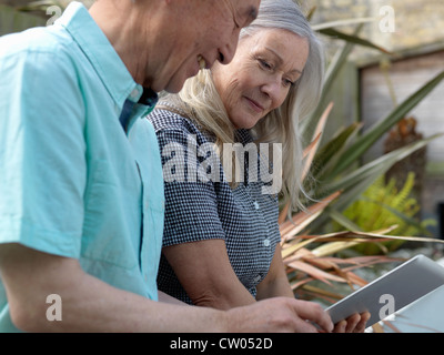 Coppia di anziani utilizzando computer tablet Foto Stock