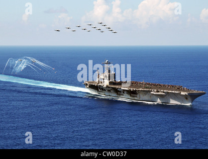 F/A-18 Hornets e Super Hornets della Carrier Air Wing (CVW) 2 volano in formazione come MH-60S elicotteri Seahawk assegnati ai Golden Falcons of Helicopter Sea Combat Squadron (HSC) 12 fuoco flares durante una dimostrazione di energia aerea sopra la portaerei di classe Nimitz USS Abraham Lincoln (CVN 72). Lincoln sta ritornando negli Stati Uniti dopo il completamento di un cambio di otto mesi di distribuzione di homeport durante il quale operò nelle aree di responsabilità della flotta degli Stati Uniti 5, 6 e 7. Foto Stock