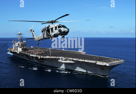 MH-60S elicottero Seahawk assegnato ai Golden Falcons di Helicopter Sea Combat Squadron (HSC) 12 vola sopra la nave portaerei di classe Nimitz USS Abraham Lincoln (CVN 72) durante una dimostrazione di potenza aerea. Lincoln sta ritornando negli Stati Uniti dopo il completamento di un cambio di otto mesi di distribuzione di homeport durante il quale operò nelle aree di responsabilità della flotta degli Stati Uniti 5, 6 e 7. Foto Stock