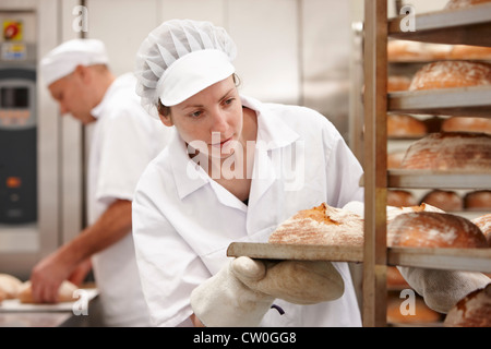 Lo chef che porta il vassoio del pane in cucina Foto Stock