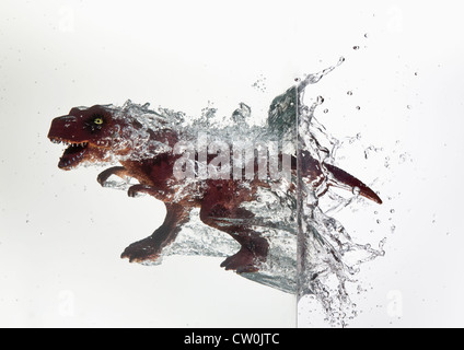 Dinosauro giocattolo immergendosi in acqua Foto Stock