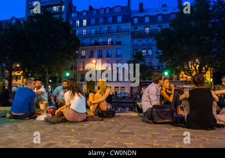 Parigi, Francia, gruppi di giovani che si aggirano, picnic, bere, su Quay nel 'Canal Saint Martin' zona, canali al tramonto Foto Stock