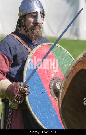 L'uomo nei primi mesi del costume medievale si erge con spada e scudo durante quella anglosassone e Viking rievocazione storica. St Albans, Regno Unito. Maggio 2012 Foto Stock