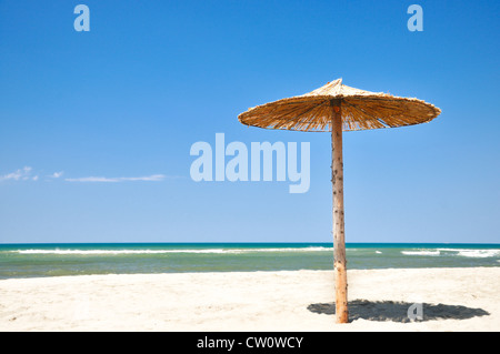 Tropical ombrello di paglia su una bella spiaggia di sabbia Foto Stock