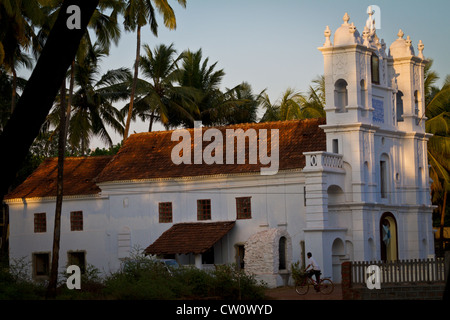 Cicli di uomo passato la chiesa cristiana in Anjuna, Goa Foto Stock