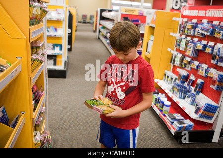 8 anno vecchio ragazzo Mexican-American, negozi per la sua terza elementare Scuola elementare fornisce in forniture per uffici Foto Stock