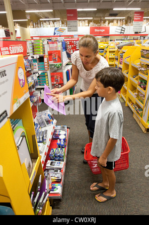 Mom ispanica prende il suo figlio di 8 anni Mexican-American figlio dello shopping di terza elementare Scuola elementare fornisce in store Foto Stock