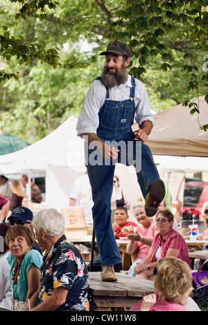 Uomo in tuta di Bib ballare una maschera su un tavolo da picnic in mezzo alla folla il Kentucky Music Festival a Iroquois Park in Kentucky Foto Stock