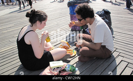 Coppia giovane picnic sulla Coney Island Boardwalk. Foto Stock