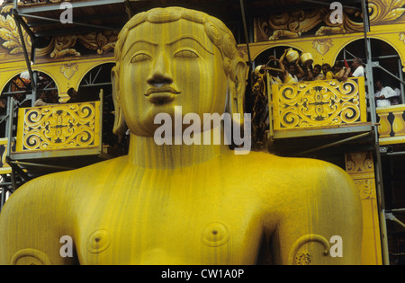 INDIA, nello stato di Karnataka, Hassan distretto, Shravana Belagola , Giainismo, festival di Jain Mahamastakabisheka, Grand consacrazione, in granito scultura monolitica del santo Signore Bahubali, il 57 piedi statua è stata scolpita da un unico pezzo di roccia datata 981 ed è uno dei più grandi free-standing statue in tutto il mondo, il festival si svolge solo una volta ogni dodici anni, migliaia di seguaci di jain raccogliere e versare le spezie colorate liquidi, latte, zucchero e polvere di fiori sulla statua da una speciale costruzione religiosa, faccia di pietra grande grande - immagine presa durante il festival dell'anno 1994 Foto Stock