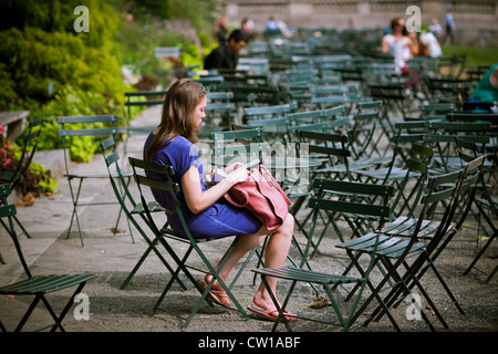 Un lettore utilizza il suo Amazon Kindle libro elettronico in Bryant Park di New York Foto Stock