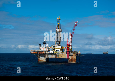 Offshore SS47 olio impianto di perforazione in Campos Basin, Rio de Janeiro, Brasile. Lavorare per la Petrobras. Barca da pesca galleggiando intorno. Foto Stock