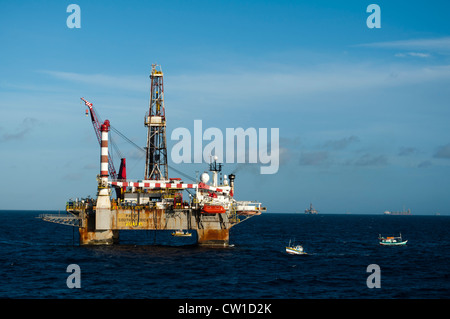 Offshore SS47 olio impianto di perforazione in Campos Basin, Rio de Janeiro, Brasile. Lavorare per la Petrobras. Barca da pesca galleggiando intorno. Foto Stock