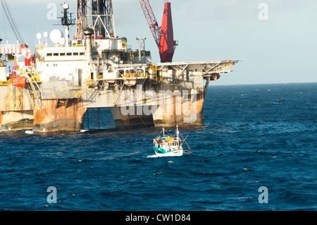 Offshore SS47 olio impianto di perforazione in Campos Basin, Rio de Janeiro, Brasile. Lavorare per la Petrobras. Barca da pesca galleggiando intorno. Foto Stock