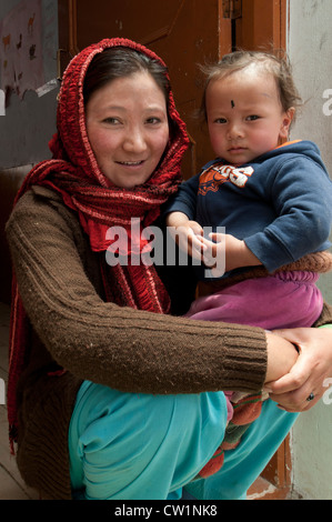 Un ritratto di una madre mentre tiene il suo figlio a Puga nomade scuola residenziale in Puga in alta montagna del Ladakh, India Foto Stock