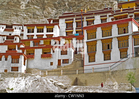 Un monaco buddista a piedi dagli edifici bianchi con rivestimento rosso del monastero di Rizong in Ladakh, India Foto Stock