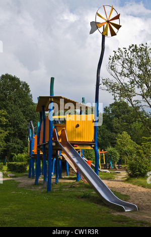 Parco giochi per bambini con scorrimenti in parco pubblico Foto Stock