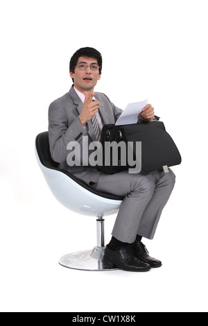 Imprenditore seduta con una valigetta Foto Stock