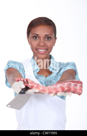 Macelleria femmina con un rack di nervature Foto Stock